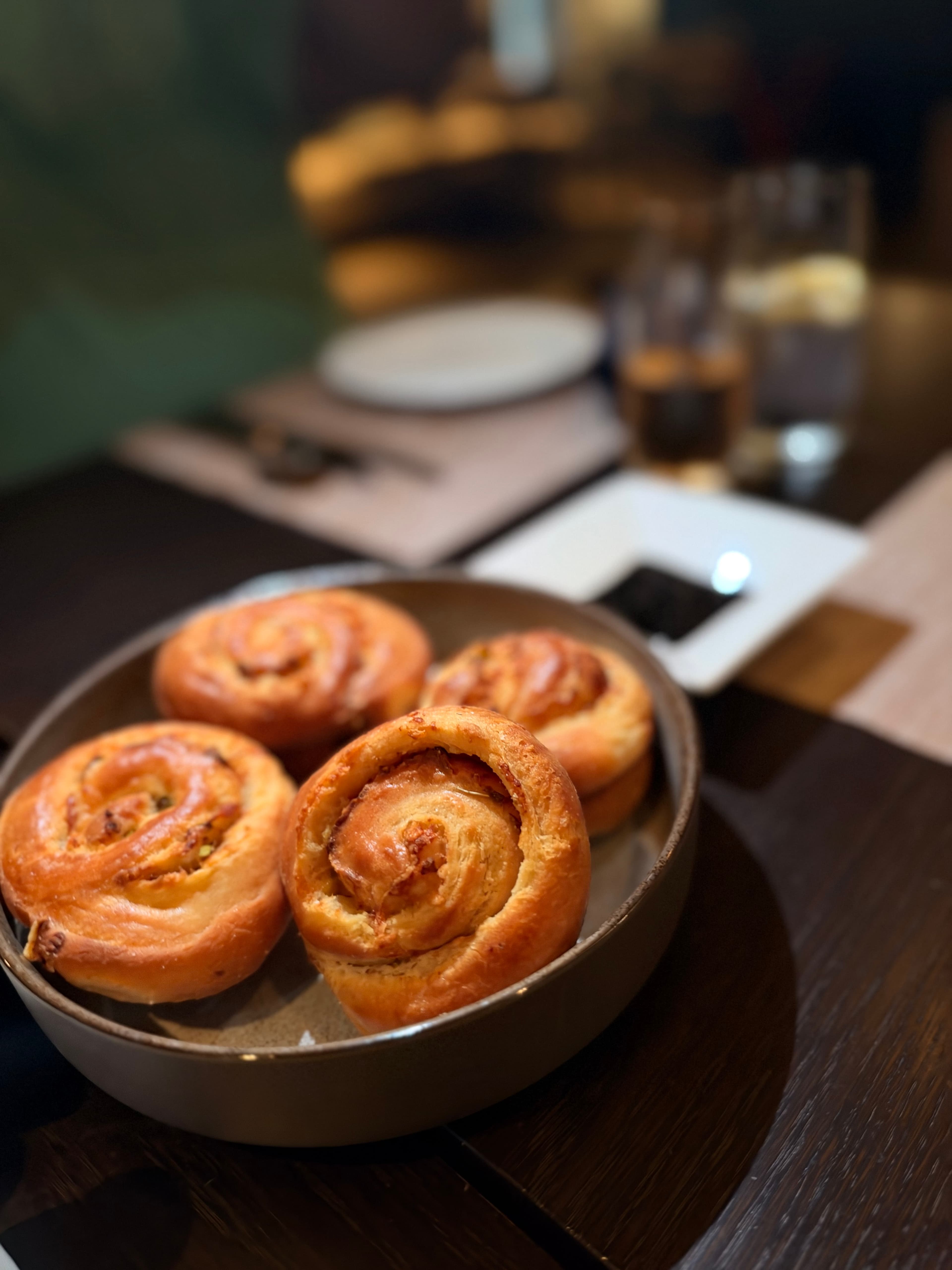 Golden spirals of milk garlic cheese bread in a shallow bowl